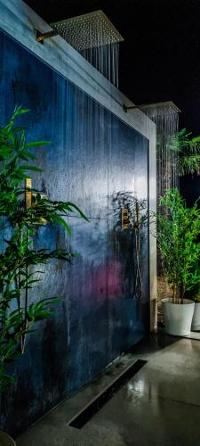 a bathroom with a blue wall with plants on it at CasaKadd002LuxuryHeated Pool Garden Patio Barbeque in Civé