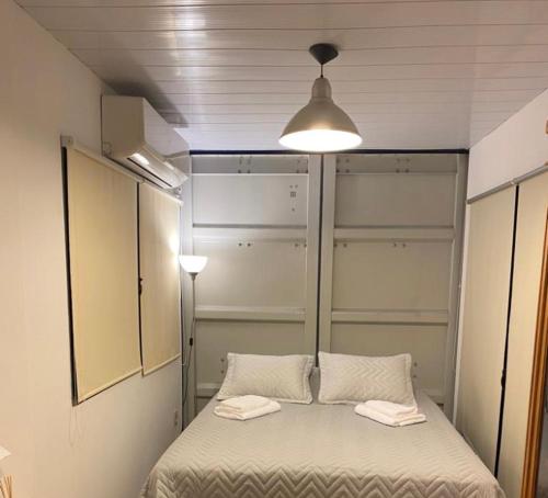 Habitación con cama con 2 almohadas y luz en ONE TRIP, en Paysandú