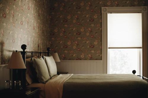 een slaapkamer met een bed en een raam met een gordijn bij Victorian in Adelaida