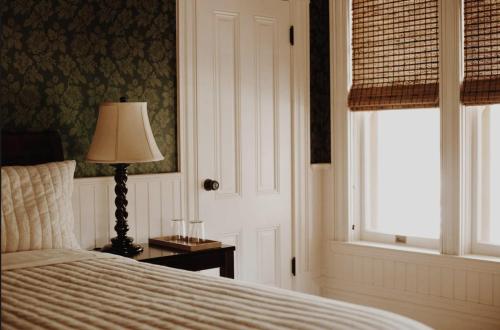 een slaapkamer met een bed, een lamp en een raam bij Victorian in Adelaida
