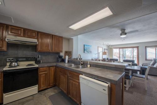 a kitchen with a sink and a stove top oven at The Plaza Condominiums by Crested Butte Mountain Resort in Mount Crested Butte