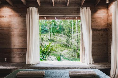 Bocas Garden Lodges في بوكاس تاون: غرفة نوم مع نافذة مطلة على غابة