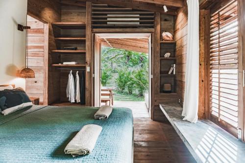 ein Schlafzimmer mit einem grünen Bett in einem Holzhaus in der Unterkunft Bocas Garden Lodges in Bocas del Toro