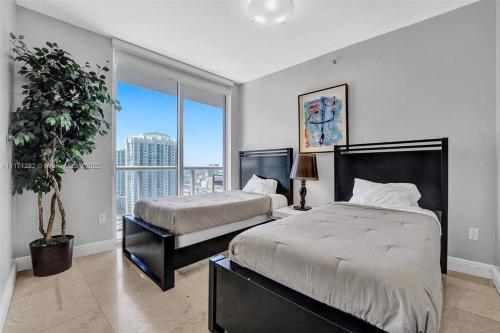 una camera da letto con due letti e una grande finestra di Waterfront Luxury Apartment 2 Bedrooms IconBrickell a Miami