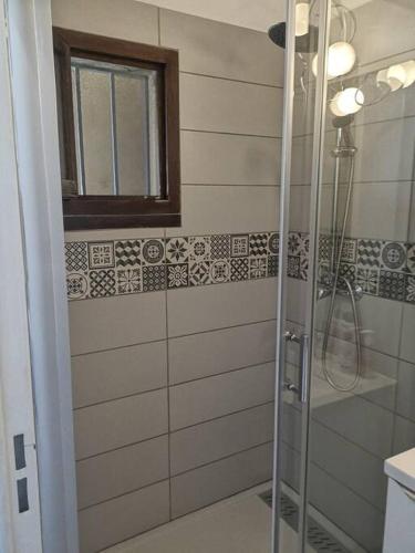 une douche avec une porte vitrée dans une salle de bain dans l'établissement T 2 à 5 mn à pied de la mer, à Sanary-sur-Mer