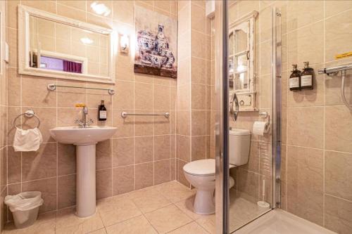 a bathroom with a toilet and a sink and a shower at Hotel LUX (Rouge) in Blackpool