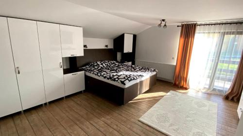 a bedroom with a bed and white cabinets and a window at Casa Priseaca 3 dormitoare in Târgovişte