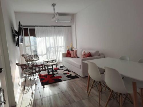 sala de estar con sofá blanco, mesa y sillas en Departamentito en Recoleta en Buenos Aires