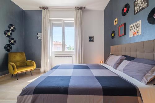 sypialnia z dużym łóżkiem i żółtym krzesłem w obiekcie Fabula Rooms 3 Suites with private bathroom w Bolonii