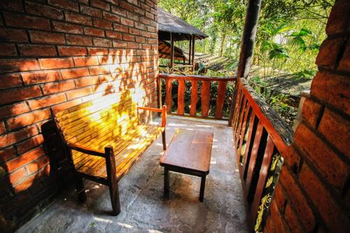 a wooden bench and a table on a brick wall at Hosteria Flor de Canela in Puyo