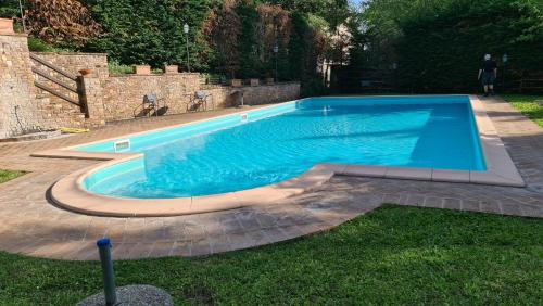 een zwembad in een tuin met een bakstenen muur bij Relax in Chianti IL BORGO 7 in Montespertoli