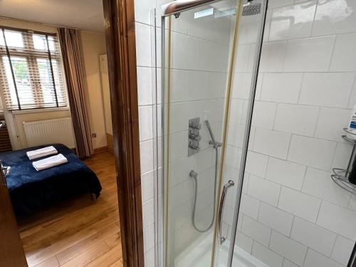 bagno con doccia e porta in vetro di London Mackenzie Suites a Londra