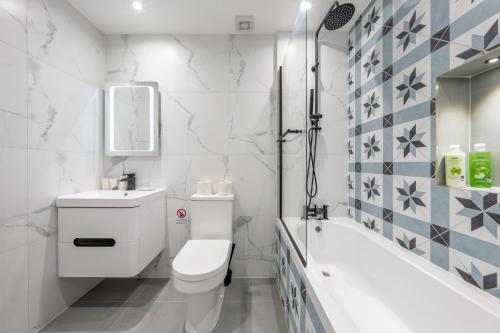 a bathroom with a toilet and a sink and a tub at 5 - West London Brand New Loft in London