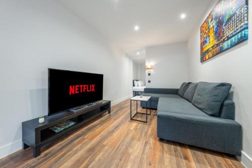 a living room with a couch and a flat screen tv at 5 - West London Brand New Loft in London