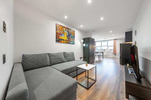 a living room with a couch and a table at 5 - West London Brand New Loft in London
