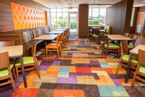a dining room with tables and chairs on a colorful floor at Fairfield Inn by Marriott Lumberton in Lumberton