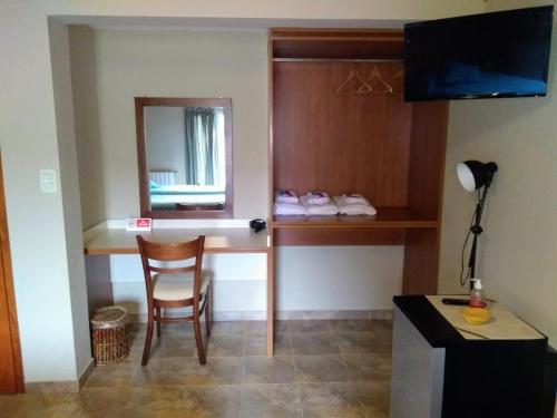 a room with a desk and a chair and a mirror at Alto Verde Hostería in El Calafate