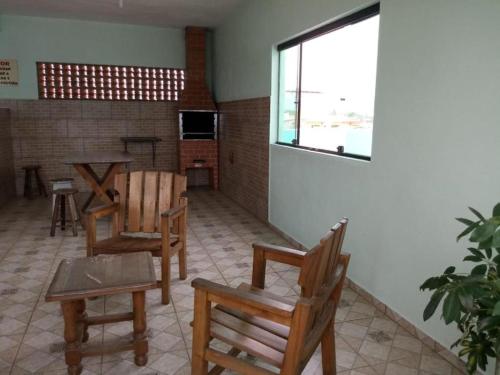 a room with chairs and a table and a window at Apartamentos Apiaí in Ilha Comprida