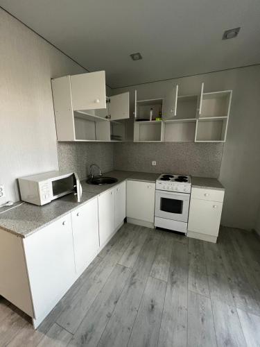 an empty kitchen with white cabinets and a stove at casa langa magazine in Floreşti