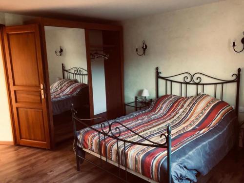 Schlafzimmer mit einem Bett, einem Spiegel und einer Tür in der Unterkunft Gîte, Sexey-Aux-Forges, 8 personnes, 180m², 4 chambres 