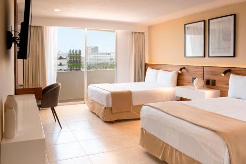 Postel nebo postele na pokoji v ubytování Hotel Calypso Cancun