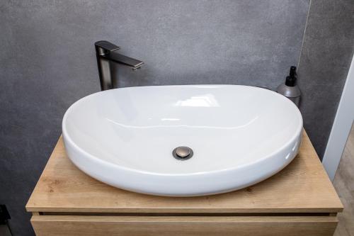 a white sink on a wooden table in a bathroom at Villa Copun with heated pool in Rab