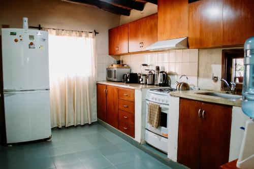a kitchen with wooden cabinets and a white refrigerator at Huaco Casa de Campo in Belén