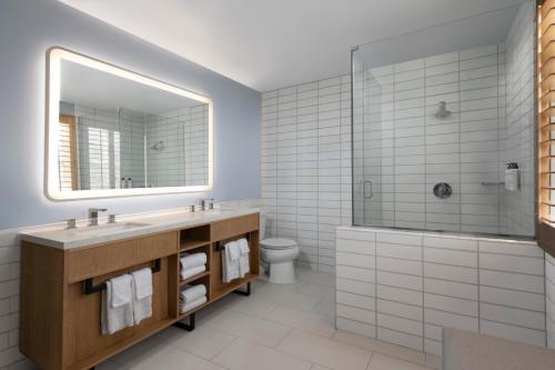 een badkamer met een wastafel, een douche en een spiegel bij Catalina Canyon Inn in Avalon