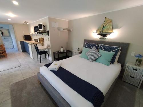 a bedroom with a large bed and a living room at Wildferns Lodge and Sailors Studio Opua in Opua