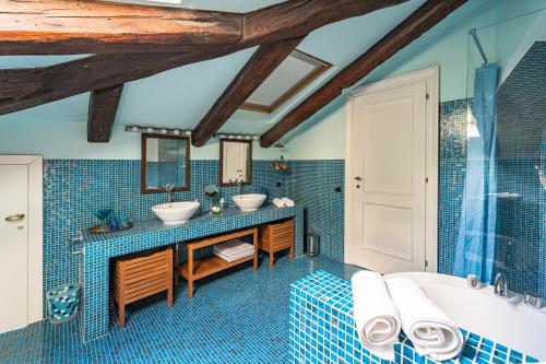 a blue tiled bathroom with two sinks and a tub at Villa Bonafata b&b in Trieste