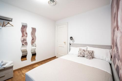 a bedroom with a white bed with two pillows on it at Villa Bonafata b&b in Trieste