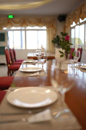 a wooden table with glasses and plates on it at Pleiku & Em Hotel by Gia Lai Tourist in Pleiku