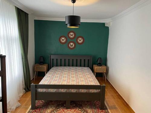 1 dormitorio con cama y pared verde en Seyoni Konaklama, en Arhavi