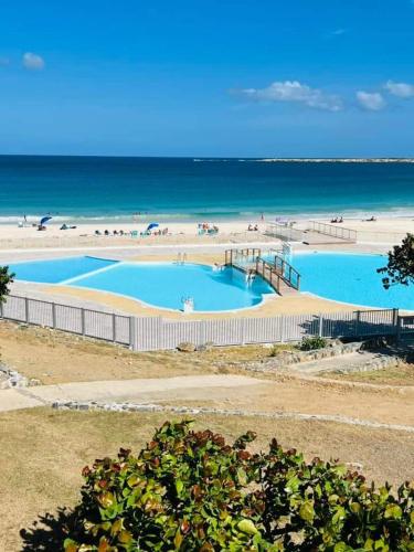 a large pool of blue water next to a beach at Happy Residence - Orient Beach 09 in Cul de Sac