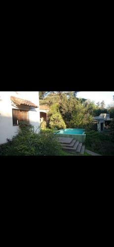 dos fotos de una casa y una piscina en Casa de las sierras en Unquillo