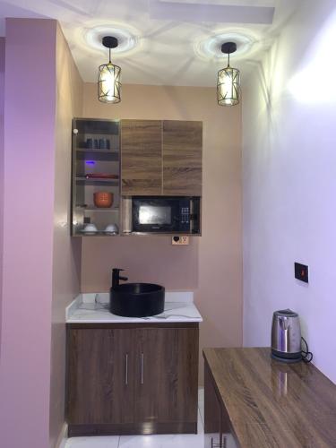 a kitchen with a sink and a microwave at Executive Royal Suite Kado in Abuja