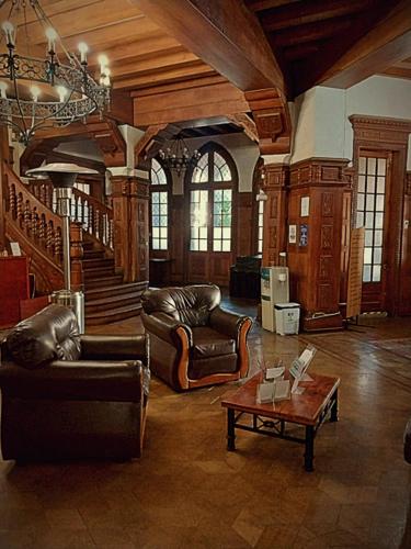 un soggiorno con mobili in pelle e tavolo di Hotel Casa del Maestro Santiago a Santiago