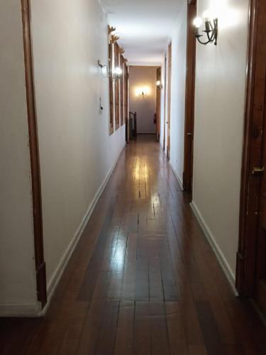 a hallway with white walls and a wooden floor at Hotel Casa del Maestro Santiago in Santiago