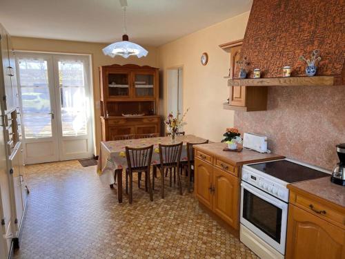 une cuisine avec une table et quelques chaises dans l'établissement Le Gîte des Marronniers - location 3* avec piscine, à Ceaux-en-Loudun