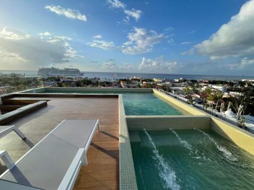a swimming pool on the roof of a building at Condo Gallo in Cozumel