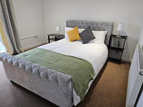 a bedroom with a bed with a gray tufted headboard at Skyline Mansel in Swansea