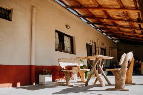 une table et des chaises devant un bâtiment dans l'établissement Huaco Casa de Campo, à Belén