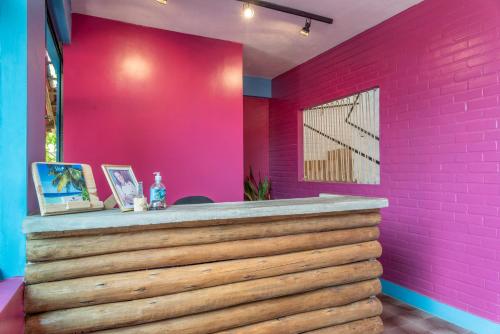 a pink bathroom with a pink wall at Vila Anauá in Japaratinga