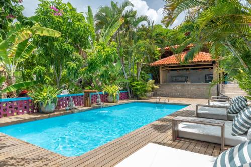 a swimming pool in front of a house with palm trees at Vila Anauá in Japaratinga