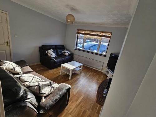 uma sala de estar com um sofá e uma mesa em 3 bedroom Semi detached em Erith