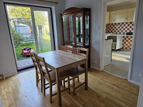 uma sala de jantar com uma mesa de madeira e cadeiras em 3 bedroom Semi detached em Erith