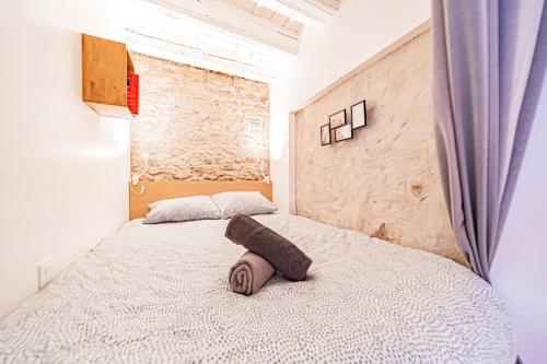 une chambre avec un lit avec un oreiller dessus dans l'établissement Le Petit St Paul - Vieux Lyon, à Lyon