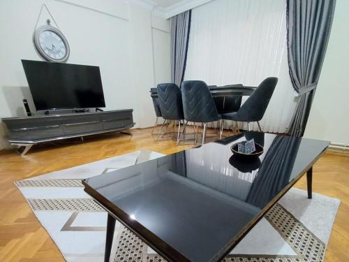 uma sala de estar com uma televisão e uma mesa e cadeiras em Appartement 1er etage Ortaköy No 3 em Istambul