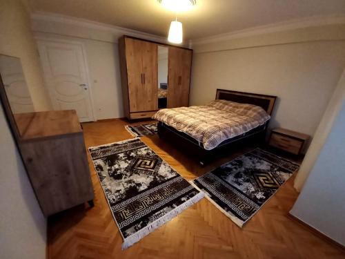 a bedroom with a bed and two rugs at Appartement 1er etage Ortaköy No 3 in Istanbul