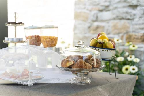 a table with a plate of bread and a bowl of fruit at Villa Bonafata b&b in Trieste